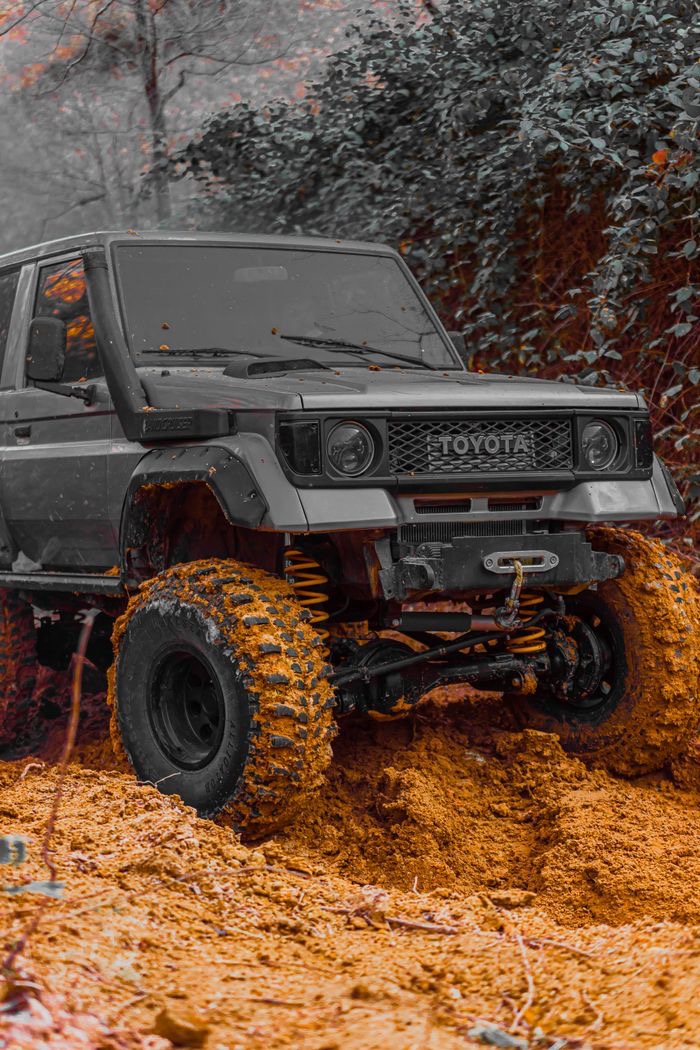 Off-road vehicle navigating a muddy forest trail